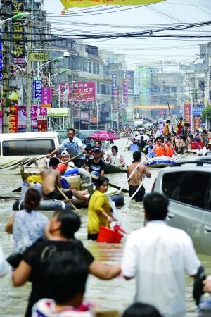 8月20日，在汕头市潮南区陈店镇，街道变水道，当地群众积极开展自救。当日，在遭受洪水围困近72小时的陈店镇，当地群众利用龙舟、木板、塑料泡沫、橡皮艇等工具，将老弱妇幼运出灾区，并运输矿泉水、食物等物资进入。 新华社发