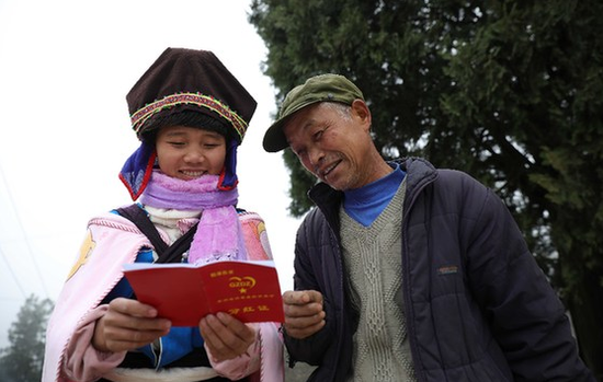 1月9日，贵州省丹寨县排调镇排结村，两名苗族村民在了解万达专项扶贫基金分红证的内容。