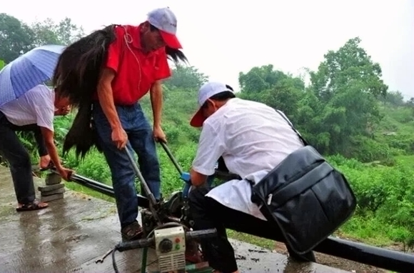 水利志愿者冒雨抢修饮水管道。 图自江津发布