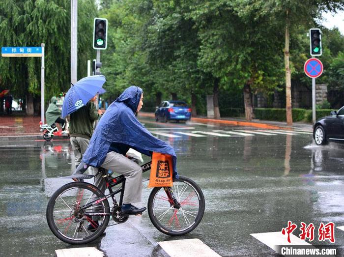 长春市民雨中出行。　郭佳 摄